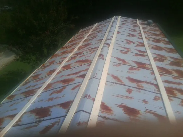 Rusted metal roof panels with new wood purlins before replacement — Storm Damage Roof Repair in Crane Hill by Roofing Brothers