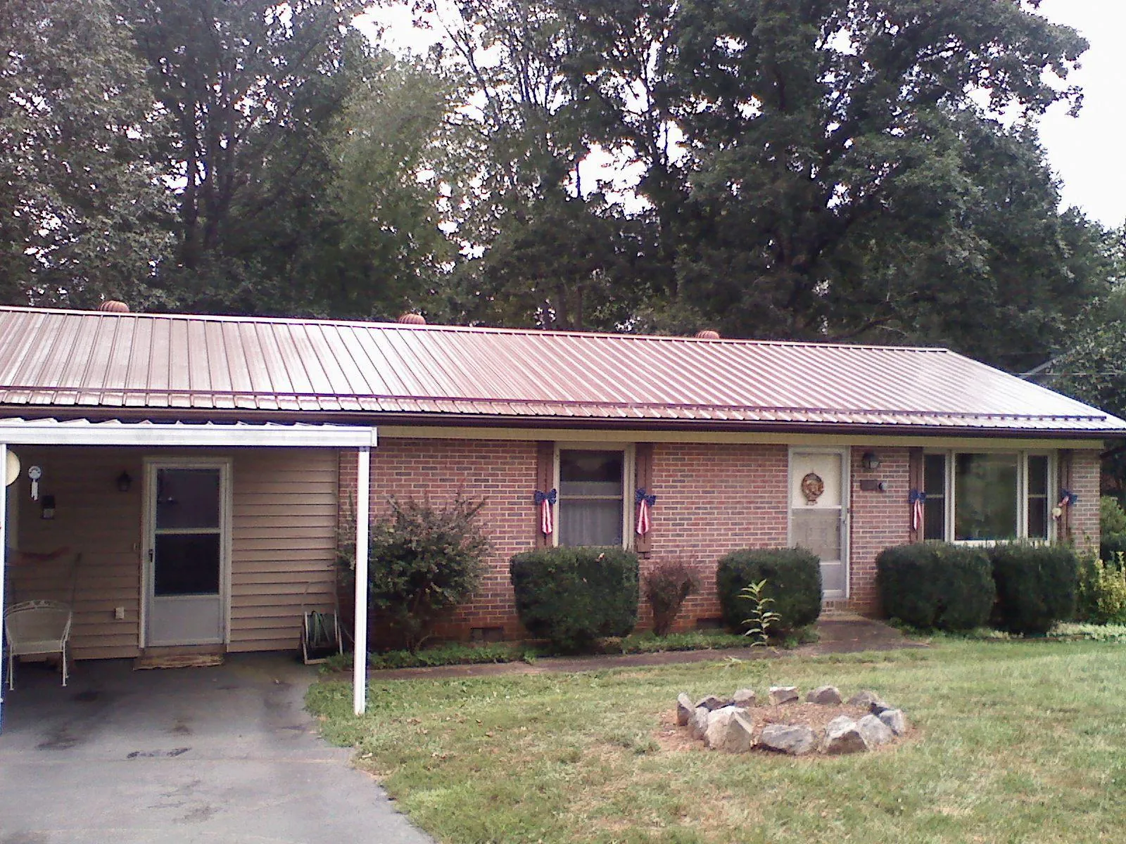 Bronze metal roof and carport on a brick ranch home — Roof Repair work by our crew in Crane Hill