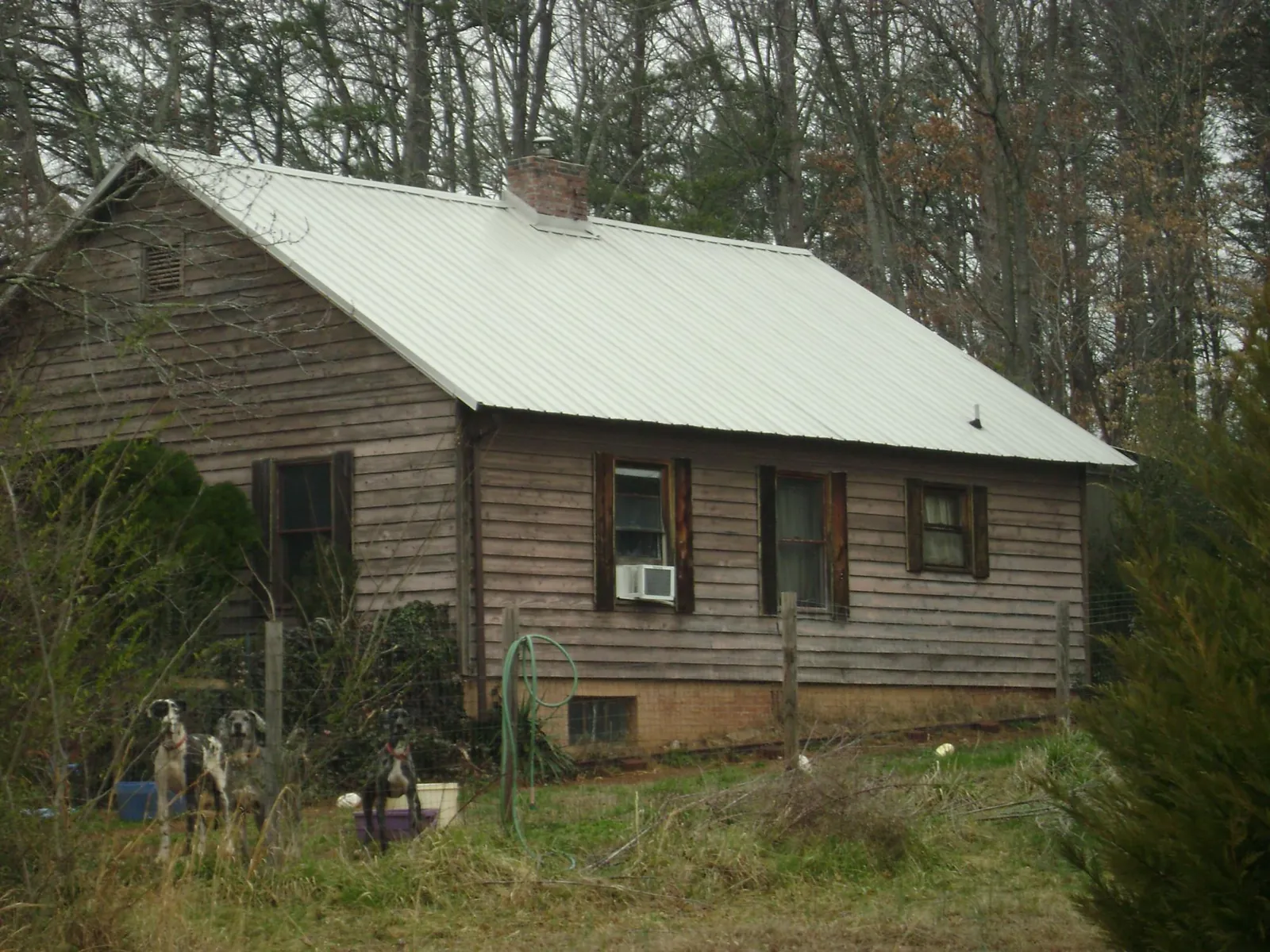 White metal roof on an old wood sided farmhouse, from a Metal Roof Installation job in Crane Hill